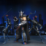 ULTIMATE SHREDDER TEENAGE MUTANT NINJA TURTLES (2012). En la serie animada Teenage Mutant Ninja Turtles de 2012, Shredder es el enemigo más formidable de las Tortugas Ninja. Su presencia eleva instantáneamente el nivel de tensión. Calculador, despiadado e impulsado por la venganza, marca la tensión de la serie cada vez que aparece en escena. A lo largo de la serie, Shredder actúa como un estratega implacable cuyo objetivo es destruir a Splinter y a sus alumnos. Su obsesión alimenta algunas de las batallas más intensas de la serie. A través de la manipulación, los duelos brutales y las alianzas inestables, sigue siendo una fuerza imparable. La figura captura con precisión su aspecto de 2012: armadura angular plateada, guanteletes con largas espadas, grebas pesadas y un casco con cuernos afilados. Una capa negra realza su imponente silueta. Los accesorios incluyen múltiples espadas intercambiables, manos adicionales, una cabeza alternativa sin máscara y una criatura Krang rosa sacada directamente de los dibujos animados. Los detalles nítidos resaltan la armadura metálica, el esculpido limpio, las articulaciones discretas y los accesorios a escala. Con 18 cm de altura, la figura ofrece una articulación sólida, perfecta para recrear los momentos icónicos de Shredder.