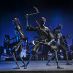 ULTIMATE FOOT SOLDIER TEENAGE MUTANT NINJA TURTLES (2012). En la serie animada Teenage Mutant Ninja Turtles de 2012, los soldados Foot representan la amenaza silenciosa y persistente del clan Foot. Siempre presentes en las sombras, operan en grupos, siguen órdenes sin dudar y empujan constantemente a las Tortugas hasta sus límites. Su papel enfatiza la estricta disciplina del clan. Ya sea en emboscadas, persecuciones o batallas coordinadas, los soldados Foot siguen siendo oponentes implacables que aumentan la tensión de cada encuentro. La figura recrea su aspecto alto y esbelto: traje negro, extremidades angulosas, máscara oscura con ojos rojos y la característica cinta roja en la cabeza. El set incluye una amplia gama de armas, como guadañas, una maza con púas, una lanza, una katana y otros accesorios fieles a la serie. Las múltiples manos intercambiables y una cabeza alternativa ofrecen una gran flexibilidad a la hora de colocar la figura. Los detalles nítidos destacan en las texturas del traje, las proporciones estilizadas, la pintura limpia y los accesorios bien elaborados. Con 18 cm de altura, la figura ofrece una articulación sólida para poses sigilosas o centradas en la acción inspiradas en los dibujos animados.