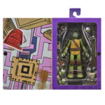 ULTIMATE DONATELLO TEENAGE MUTANT NINJA TURTLES (2012). En la serie animada Teenage Mutant Ninja Turtles de 2012, Donatello es el cerebro técnico del equipo. Aborda cada situación con precisión, equilibrando inventos, improvisación y un profundo sentido de la responsabilidad. Su mentalidad tranquila y lógica mantiene al grupo con los pies en la tierra mientras sus hermanos se lanzan al ataque. A lo largo de la serie, Donnie es a menudo quien idea soluciones cuando las cosas se complican. Ya sea construyendo nuevos equipos, analizando amenazas u ofreciendo un apoyo silencioso, se erige como la fuerza estabilizadora y el solucionador de problemas del equipo. La figura captura con precisión su aspecto de 2012: caparazón beige y marrón, piel verde, máscara morada y almohadillas de armadura marrones. Su expresión neutra se complementa con una cara alternativa más expresiva. El conjunto de accesorios es muy completo e incluye bastones segmentados, artilugios, manos intercambiables, visera tecnológica, porción de pizza, huevo, pieza de armadura e incluso un pollo mutante sacado directamente de la serie. El esculpido nítido, la aplicación limpia de la pintura y las articulaciones bien integradas realzan la presencia de la figura. Con 18 cm de altura, ofrece una articulación sólida para posar de forma dinámica y recrear escenas de la serie.