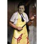 LEATHERFACE CLOTHED THE TEXAS CHAINSAW MASSACRE. En La matanza de Texas, Leatherface provoca una sensación inmediata de terror. Callado, impredecible y siempre oculto tras su máscara, encarna el peligro en estado puro y contribuye a crear la atmósfera opresiva de la película. Su papel sigue la trayectoria de un personaje aterrador e inolvidable. Atrapado en una familia desquiciada e impulsado por impulsos violentos, Leatherface ataca sin una lógica clara, lo que hace que cada una de sus apariciones resulte aún más inquietante. La figura refleja su aspecto característico: máscara cosida, camisa a rayas claras, corbata oscura y un gran delantal amarillo marcado con manchas rojas. Su despeinado cabello negro, sus pantalones oscuros y sus zapatos resistentes están fielmente recreados. Las imágenes muestran múltiples accesorios, incluyendo un martillo y una motosierra. La ropa de tela típica de la línea Clothed de NECA añade realismo. Los detalles nítidos destacan en la textura del delantal, la escultura de la máscara, los pliegues de la ropa y los accesorios de buen tamaño. Con una altura de 20 cm, la figura tiene una sólida presencia en la estantería y se puede colocar con diferentes accesorios.