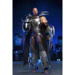 ULTIMATE SHREDDER TEENAGE MUTANT NINJA TURTLES (2012). En la serie animada Teenage Mutant Ninja Turtles de 2012, Shredder es el enemigo más formidable de las Tortugas Ninja. Su presencia eleva instantáneamente el nivel de tensión. Calculador, despiadado e impulsado por la venganza, marca la tensión de la serie cada vez que aparece en escena. A lo largo de la serie, Shredder actúa como un estratega implacable cuyo objetivo es destruir a Splinter y a sus alumnos. Su obsesión alimenta algunas de las batallas más intensas de la serie. A través de la manipulación, los duelos brutales y las alianzas inestables, sigue siendo una fuerza imparable. La figura captura con precisión su aspecto de 2012: armadura angular plateada, guanteletes con largas espadas, grebas pesadas y un casco con cuernos afilados. Una capa negra realza su imponente silueta. Los accesorios incluyen múltiples espadas intercambiables, manos adicionales, una cabeza alternativa sin máscara y una criatura Krang rosa sacada directamente de los dibujos animados. Los detalles nítidos resaltan la armadura metálica, el esculpido limpio, las articulaciones discretas y los accesorios a escala. Con 18 cm de altura, la figura ofrece una articulación sólida, perfecta para recrear los momentos icónicos de Shredder.