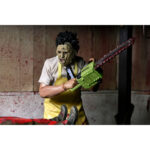 LEATHERFACE CLOTHED THE TEXAS CHAINSAW MASSACRE. En La matanza de Texas, Leatherface provoca una sensación inmediata de terror. Callado, impredecible y siempre oculto tras su máscara, encarna el peligro en estado puro y contribuye a crear la atmósfera opresiva de la película. Su papel sigue la trayectoria de un personaje aterrador e inolvidable. Atrapado en una familia desquiciada e impulsado por impulsos violentos, Leatherface ataca sin una lógica clara, lo que hace que cada una de sus apariciones resulte aún más inquietante. La figura refleja su aspecto característico: máscara cosida, camisa a rayas claras, corbata oscura y un gran delantal amarillo marcado con manchas rojas. Su despeinado cabello negro, sus pantalones oscuros y sus zapatos resistentes están fielmente recreados. Las imágenes muestran múltiples accesorios, incluyendo un martillo y una motosierra. La ropa de tela típica de la línea Clothed de NECA añade realismo. Los detalles nítidos destacan en la textura del delantal, la escultura de la máscara, los pliegues de la ropa y los accesorios de buen tamaño. Con una altura de 20 cm, la figura tiene una sólida presencia en la estantería y se puede colocar con diferentes accesorios.