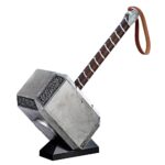 MJOLNIR THOR HAMMER ELECTRONIC MARVEL LEGENDS SERIES. Hasbro reintroduce en su colección Marvel Legends Series esta réplica electrónica premium de Mjölnir, el martillo del dios Thor, basada en su icónica aparición en las películas del universo cinematográfico de "Marvel". Este martillo a escala 1:1 mide aproximadamente 50 cm de largo y está fabricado en PVC con un nivel de detalle excepcional. Incluye correa para la muñeca y pomo con acabado premium. Cuenta con efectos de luz LED y sonido activados por voz: al pronunciar el nombre de Thor, se ilumina el símbolo de las runas de Odín. Requiere 3x pilas AA (no incluidas). Incluye manual de instrucciones. Se presenta en una caja ilustrada de colección. UNIDADES LIMITADAS.